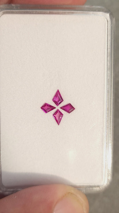 The four pink kite rubies shown together in changing face-up and tilted views of their white tray.