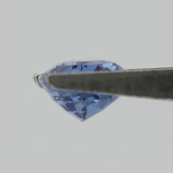 Video of the exact pear-shaped light blue sapphire rotating in tweezers, followed by a between-fingers scale view.