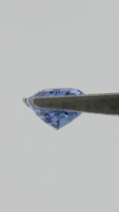 Video of the exact pear-shaped light blue sapphire rotating in tweezers, followed by a between-fingers scale view.