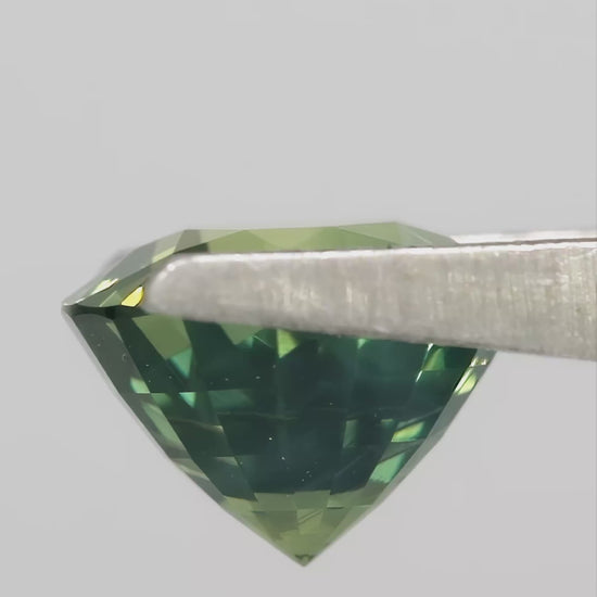 Video showing the olive teal green round sapphire through changing viewing angles.