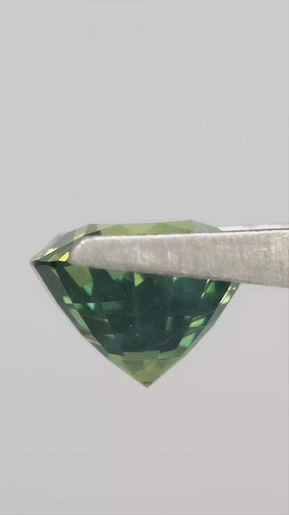 Video showing the olive teal green round sapphire through changing viewing angles.