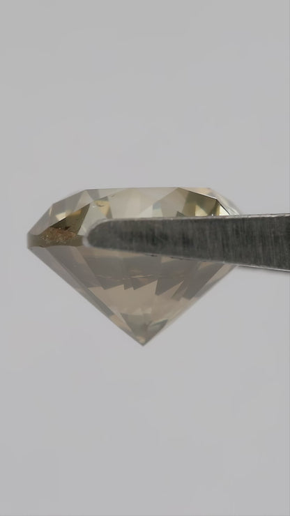 4K video of the exact KL445 round brilliant diamond rotating through face-up, angled, profile and hand-scale views, showing olive champagne color and prominent visible features.
