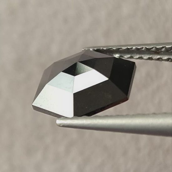 Video of the exact 1.64 ct natural black rose-cut geometric hexagon diamond, showing silver-and-black reflections as it moves.