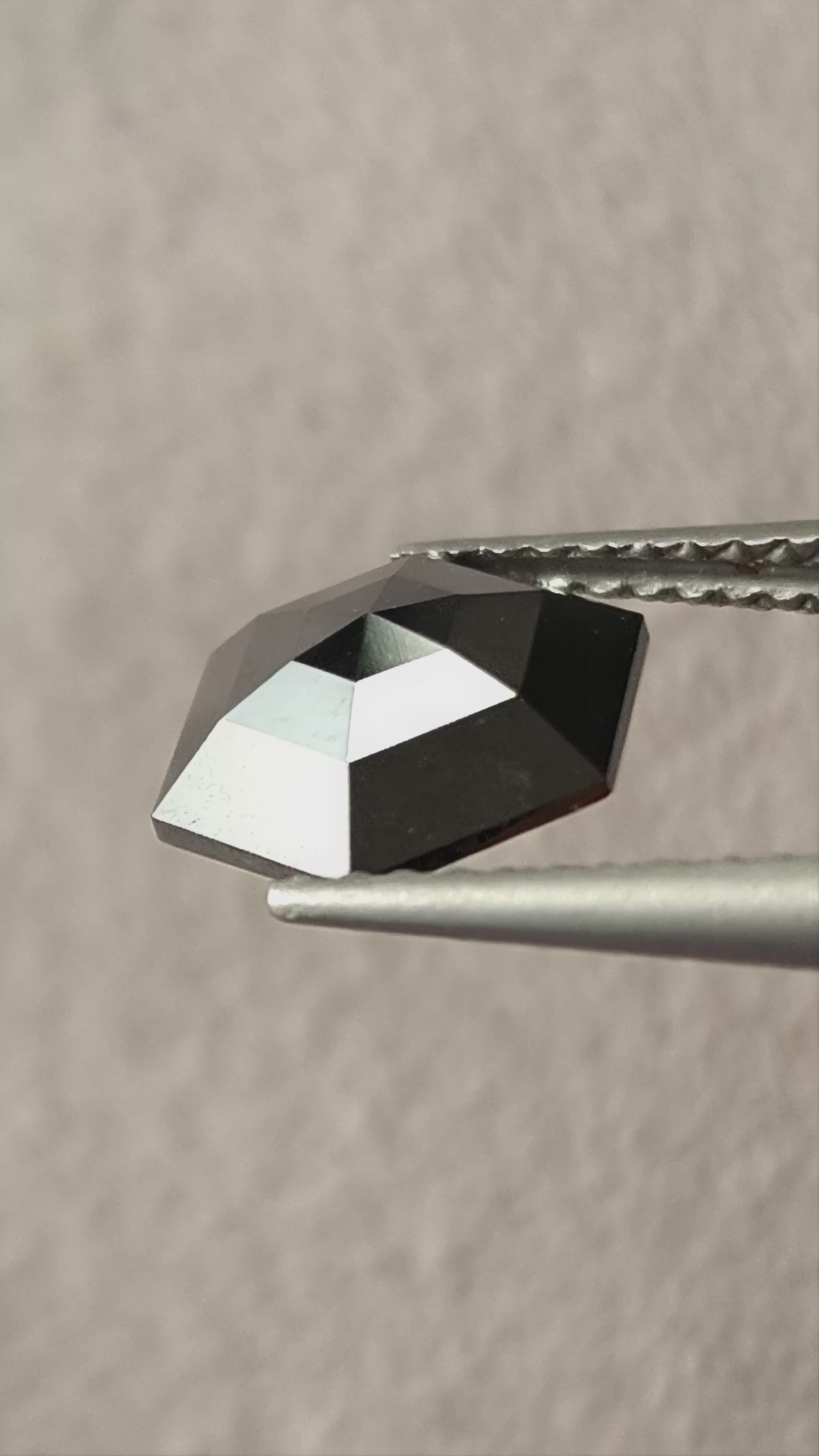 Video of the exact 1.64 ct natural black rose-cut geometric hexagon diamond, showing silver-and-black reflections as it moves.
