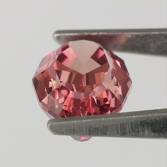 Finished video of the orange-pink sapphire in tweezers and on fingers, including a labelled backside view.