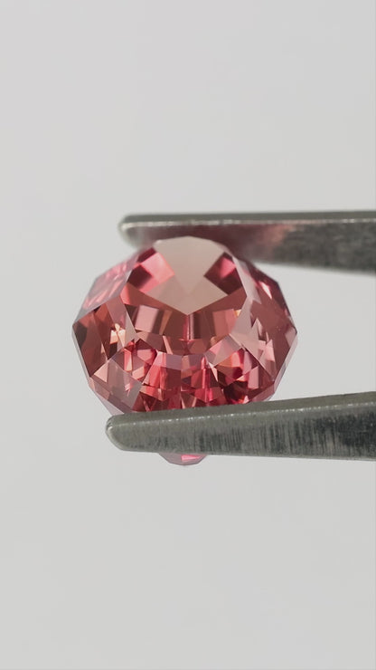 Finished video of the orange-pink sapphire in tweezers and on fingers, including a labelled backside view.