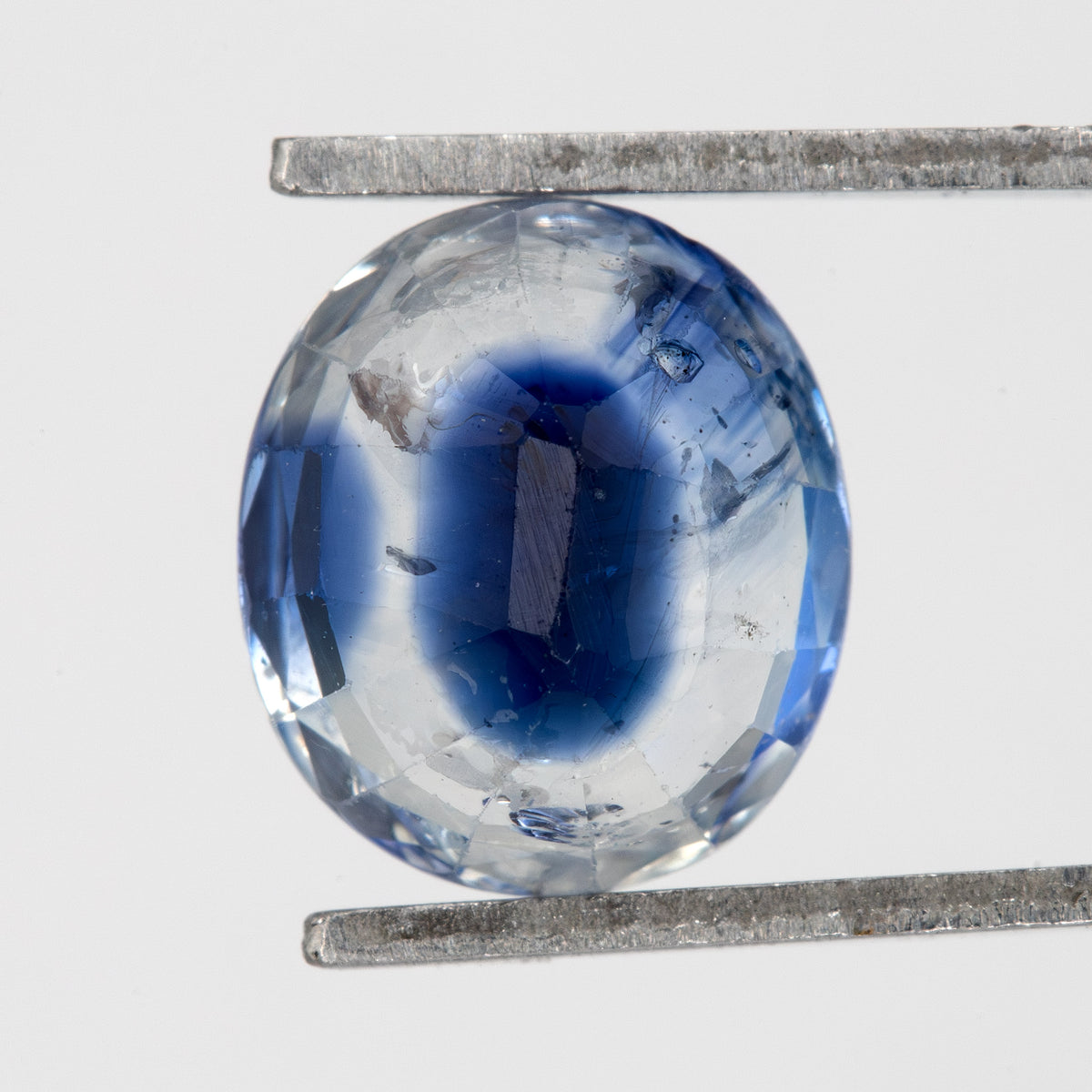 Back view of the oval blue sapphire, showing the pavilion faceting and outline.