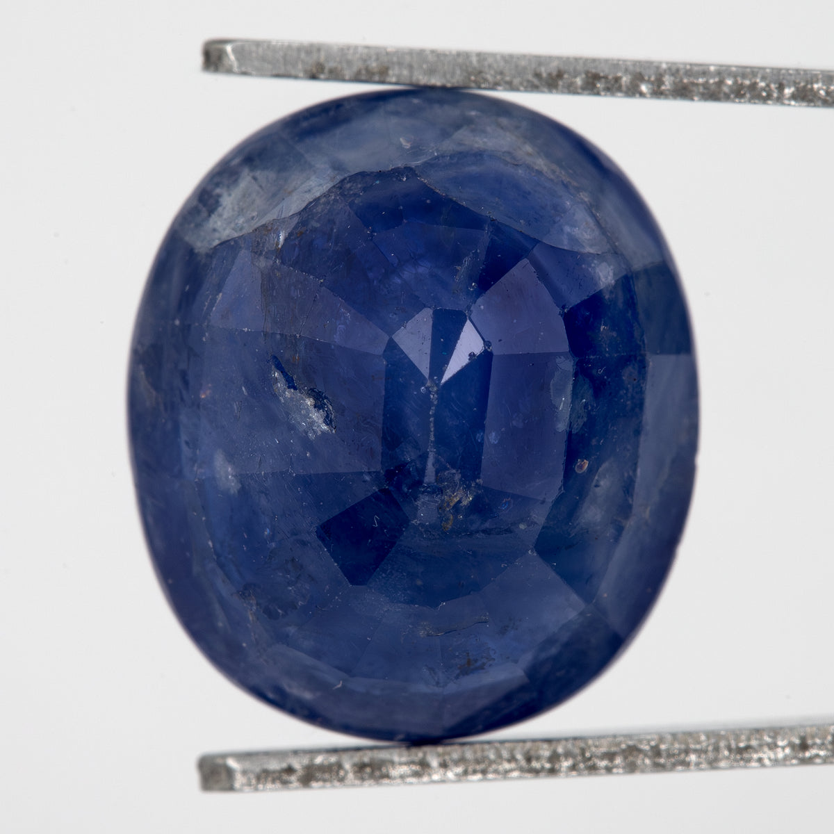 Back view of the oval blue sapphire, showing the pavilion faceting and outline.
